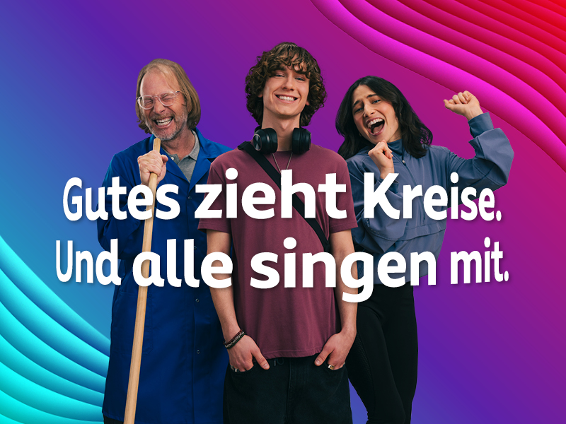 Ein Blau bis Lila-Pinker Farbverlauf im Hintergrund. Darauf sind drei Menschen fröhlich singend zu sehen: Ein Hausmeister, der seinen Besen als Mikrofon benutzt, einen coolen Teenager und eine junge Frau, die eine Wanderin darstellen soll. Darüber steht in weißer Schrift: "Gutes zieht Kreise. Und alle singen mit."